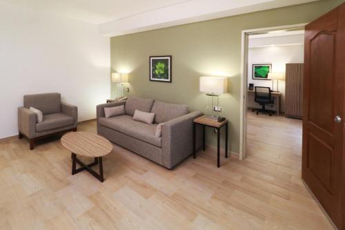 a living room with a couch and a chair at Wyndham Garden Monterrey Valle Real in Monterrey