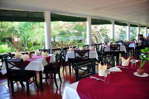 un restaurante con mesas y sillas con manteles rojos y blancos en Heritage Belihuloya Resort, en Belihuloya