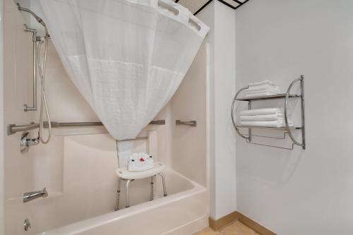 La salle de bains est pourvue d'une baignoire et d'une douche avec rideau de douche. dans l'établissement Super 8 by Wyndham Custer/Crazy Horse Area, à Custer