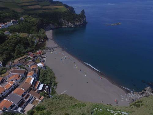 an aerial view of a beach with houses and the ocean at Casa da Ribeira dos Moinhos in Ribeira Grande