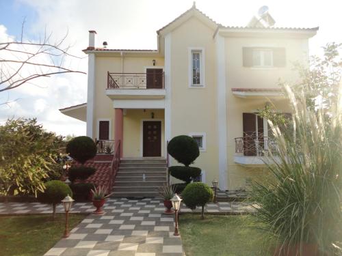a large white house with a checkered courtyard at Villa Elpida in Svoronata