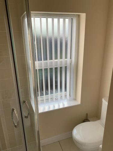 a bathroom with a shower and a toilet and a window at Smeaton serviced Accommodation in Liverpool