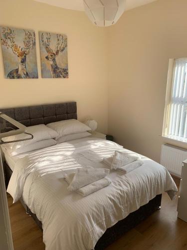 a bed in a bedroom with two paintings on the wall at Smeaton serviced Accommodation in Liverpool
