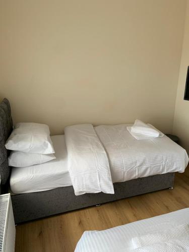 a bed with white sheets and pillows in a room at Smeaton serviced Accommodation in Liverpool