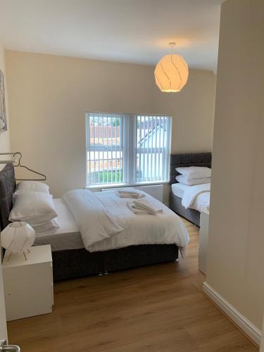 a bedroom with two beds and a window at Smeaton serviced Accommodation in Liverpool