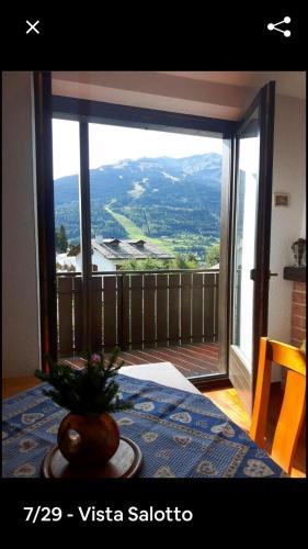 Cette chambre dispose d'une grande fenêtre offrant une vue sur la montagne. dans l'établissement bormio appartamento panoramico, à Bormio