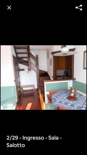 - un salon avec une table et un escalier dans l'établissement bormio appartamento panoramico, à Bormio