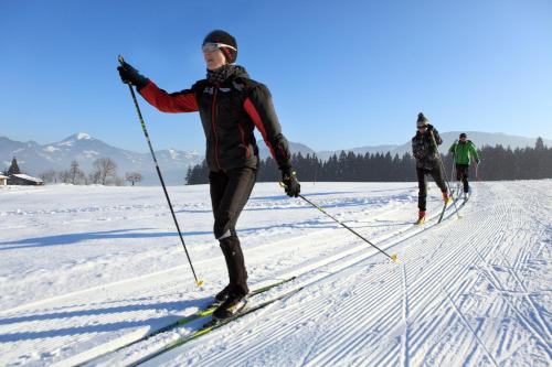 three people cross country skiing in the snow at Appartements Oberhauser in Westendorf