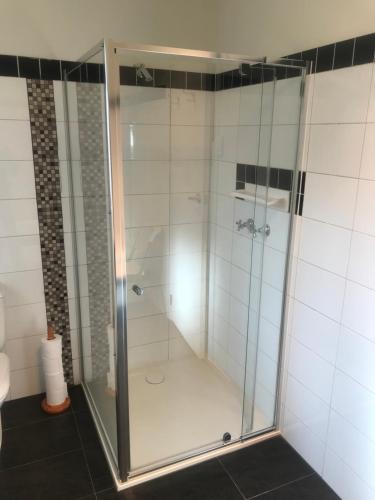 a shower with a glass door in a bathroom at OCEAN VIEWS in Warrnambool