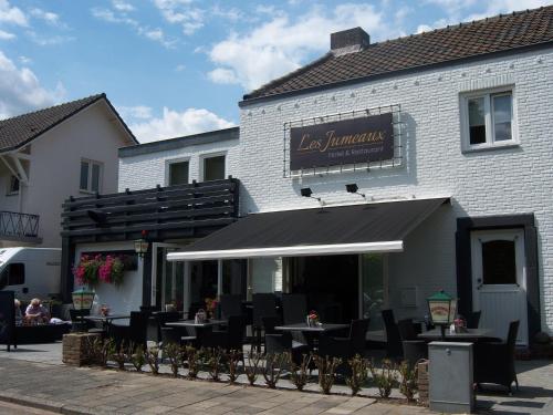 a restaurant with tables and chairs in front of a building at Hotel Restaurant Les Jumeaux in Gulpen