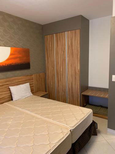 a bedroom with a bed and a painting on the wall at Barretos Park Hotel - Condo Hotel in Barretos