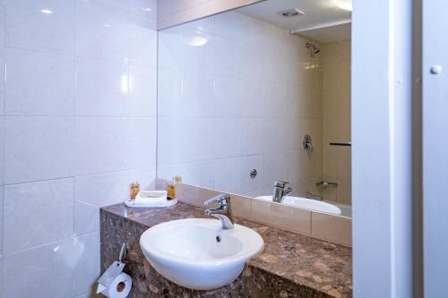 uma casa de banho com um lavatório e um espelho em Kingsgate Hotel Dunedin em Dunedin