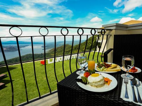 a table with a plate of food and wine glasses at The Lake Hotel Tagaytay in Tagaytay