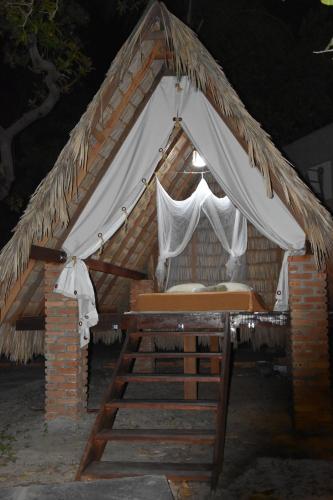 a tent with a bed in the middle at Pousada Velho Bateau in Atins