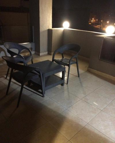 a table and chairs on a balcony at night at NewCity Hotel & Suites in Cairo