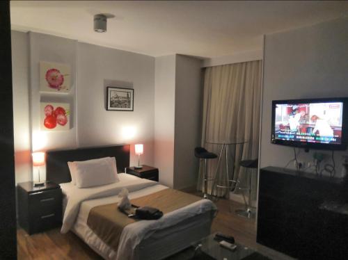 a hotel room with a bed and a flat screen tv at NewCity Hotel & Suites in Cairo