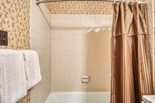 a bathroom with a tub and a shower curtain at Snowfire 209B in Angel Fire