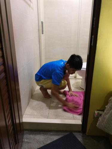 a boy in a bathroom playing with a pink towel at mydeer backpacker in Tainan