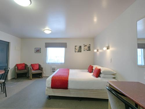 a bedroom with a bed and a table and chairs at Bella Vista Motel Westport in Westport
