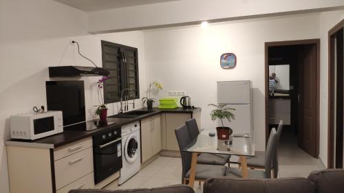 a small kitchen with a table and a microwave at Le Shanti - la paix in Ravine des Cafres-les Bas