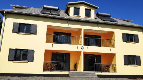 a yellow building with black windows and a balcony at Le Shanti - la paix in Ravine des Cafres-les Bas