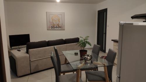 a living room with a couch and a glass table at Le Shanti - la paix in Ravine des Cafres-les Bas