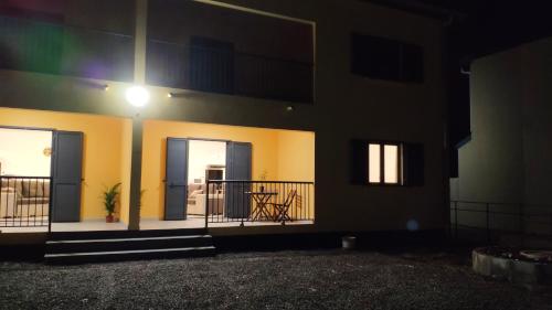 a building with two doors and a balcony at night at Le Shanti - la paix in Ravine des Cafres-les Bas
