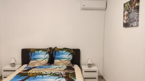 a bedroom with a bed with a poster on the wall at Le Shanti - la paix in Ravine des Cafres-les Bas