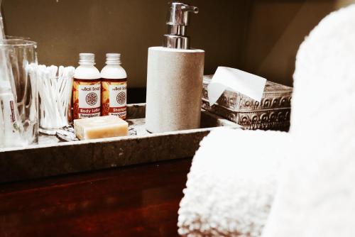 a bathroom counter with a sink with a bottle of soap at Kalua Boutique Bungalows in Gili Trawangan