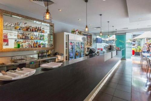 a bar in a restaurant with a counter and chairs at S&P Apartments - Albert St in Brisbane