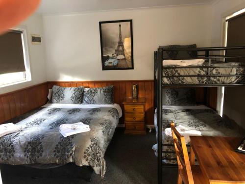 a bedroom with two beds and a bunk bed at Bendigo Bush Cabins in Bendigo