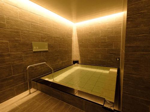 a bathroom with a bath tub with a shower at Matsuyama New Grand Hotel in Matsuyama