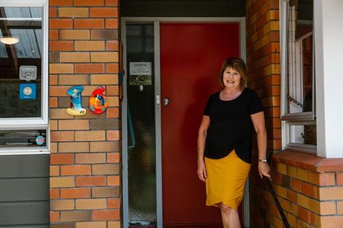 a woman standing in front of a red door at The Nunnery in Te Aroha