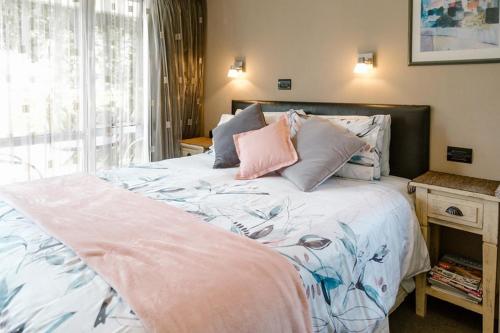 ein Schlafzimmer mit einem großen Bett mit Kissen darauf in der Unterkunft The Nunnery in Te Aroha