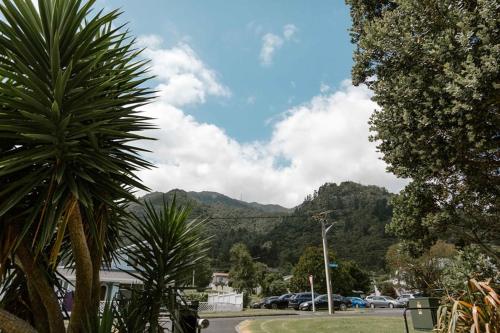 a parking lot with cars parked in front of a mountain at The Nunnery in Te Aroha