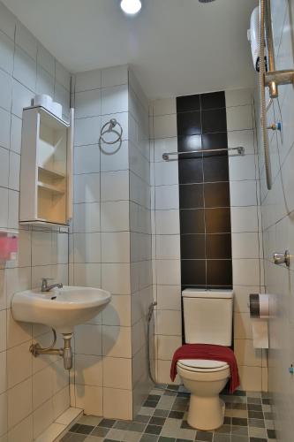 a bathroom with a toilet and a sink at Harrys Hotel Bar & Restaurant in Pattaya