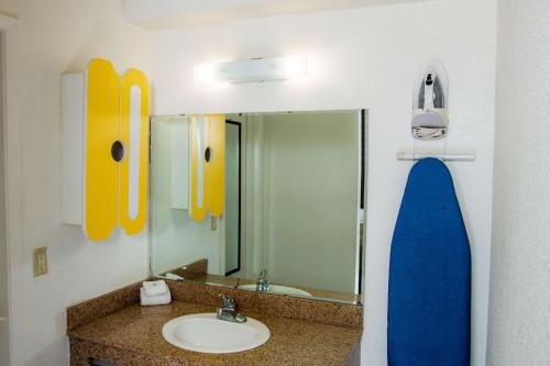 a bathroom with a sink and a mirror and a surfboard at Studio 6-San Antonio, TX - Lackland AFB in San Antonio