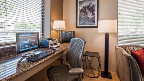 
a desk with a laptop computer and a chair at Best Western Apache Junction Inn in Apache Junction
