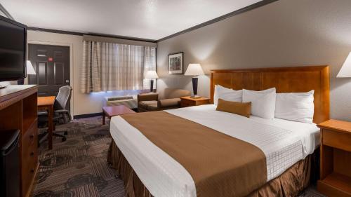 a hotel room with a large bed and a desk at Best Western Apache Junction Inn in Apache Junction