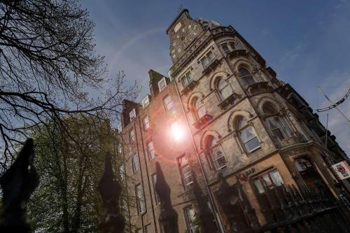 a building with the sun shining on it at Best Western Queens Hotel in Dundee