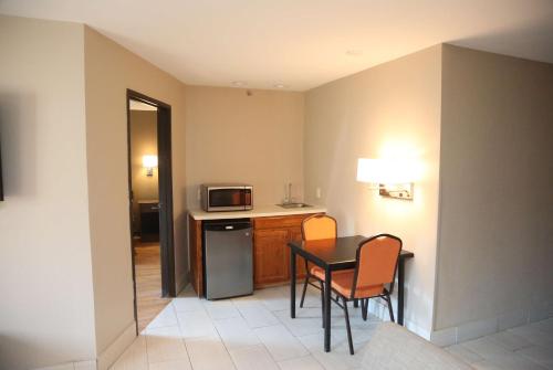 a small kitchen with a table and a microwave at Super 8 by Wyndham Portsmouth in Portsmouth