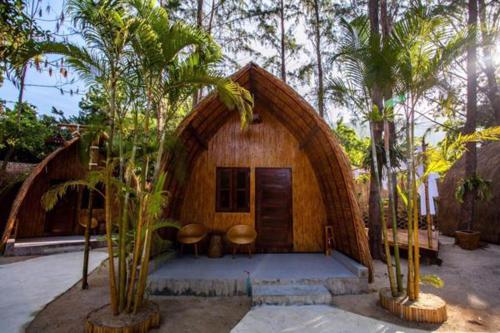 a small house with a round roof with palm trees at Cicada Lanta in Ko Lanta