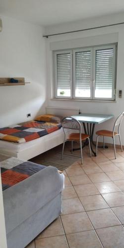 a living room with a bed and a table and chairs at eco Studio in Rijeka