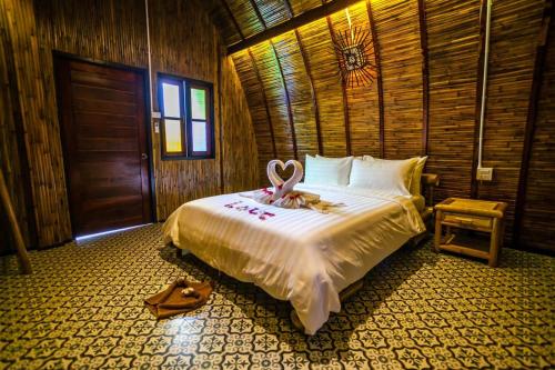 a bedroom with a bed with a swan on it at Cicada Lanta in Ko Lanta