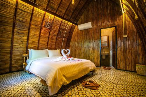 a bedroom with a bed with a towel on it at Cicada Lanta in Ko Lanta