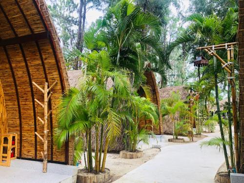 a group of palm trees in front of a building at Cicada Lanta in Ko Lanta