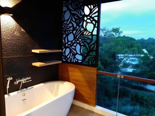 a bathroom with a bath tub and a window at Reiz - Private Residence in Chiang Mai