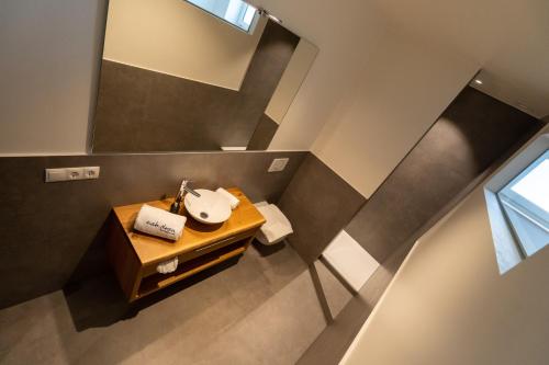 einen Blick über ein Bad mit einem Waschbecken und einem Spiegel in der Unterkunft Aparthotel nah dran in Dingolfing