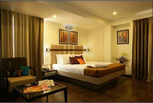 a hotel room with a bed and a table at Hotel Utsav Deluxe in Pune