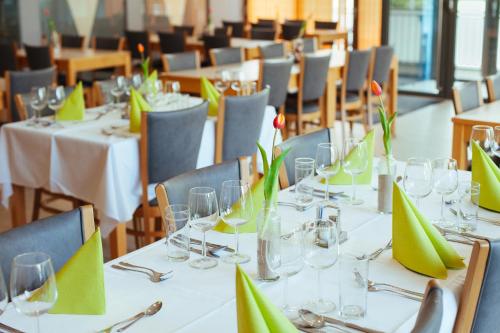 een eetkamer met witte tafels en stoelen met groene servetten bij Kultur- und Sportvereinigung der Wiener Gemeindebediensteten in Wenen